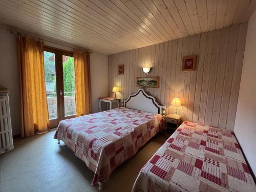 a bedroom with a bed and a large window at Gemeaux B, appartement proche pistes de ski et village NOUVEAU A LA LOCATION in La Clusaz