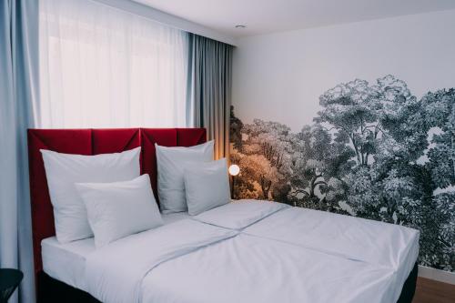 a bedroom with a white bed with a red headboard at Anaberg in Nowa Ruda