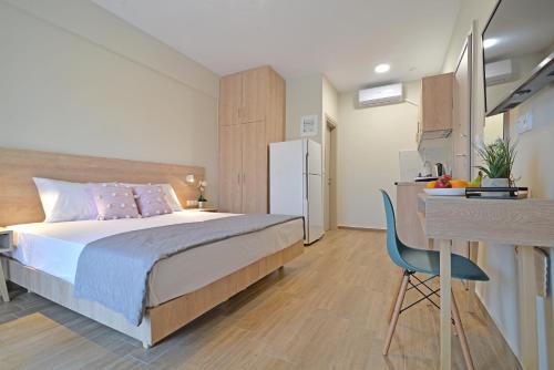 1 dormitorio con cama, escritorio y cocina en Niel Holiday Apartments, Panel Hospitality Homes & Villas en Leptokarya