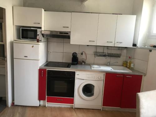 une cuisine avec des placards rouges et blancs et un lave-linge dans l'établissement Republique, à Marseille
