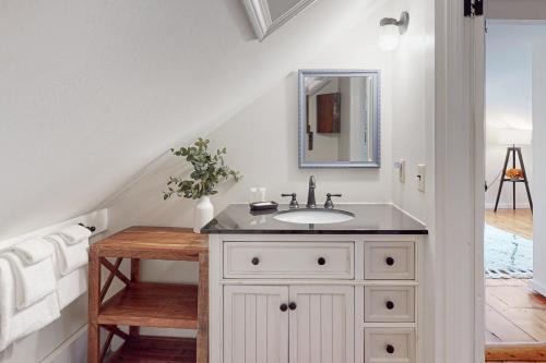 La salle de bains blanche est pourvue d'un lavabo et d'un miroir. dans l'établissement The Adams Mill Farm House, à Stowe