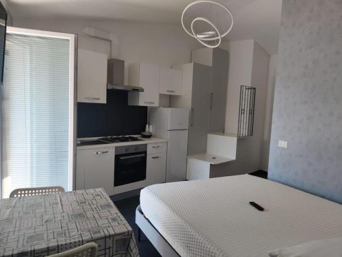 a small kitchen with a table and a bed in a room at Studio Flat Verona 1 balcone in Verona