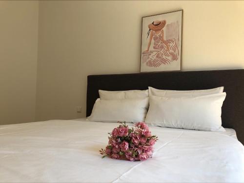 um ramo de flores sentado em cima de uma cama em Moderne Alpenblick Apartment em Friedrichshafen