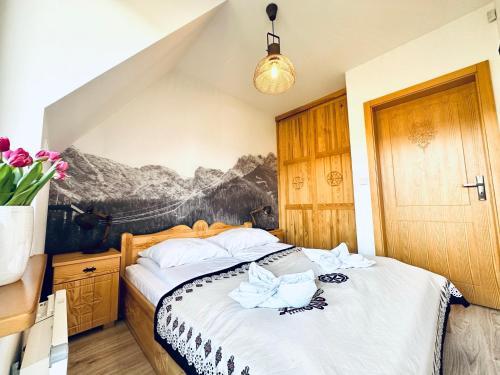 a bedroom with a bed with two towels on it at Domek Giewont in Zakopane