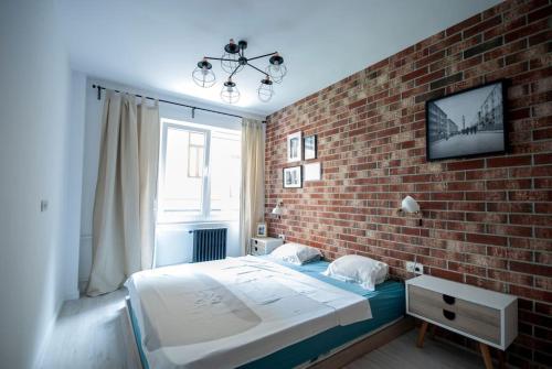 a bedroom with a brick wall and a large bed at Retro MidTown Apartment in Bucharest