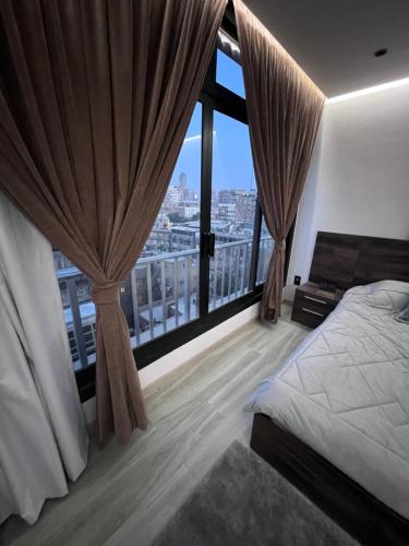 a bedroom with a bed and a large window at Zamalek Skyline Condo in Cairo