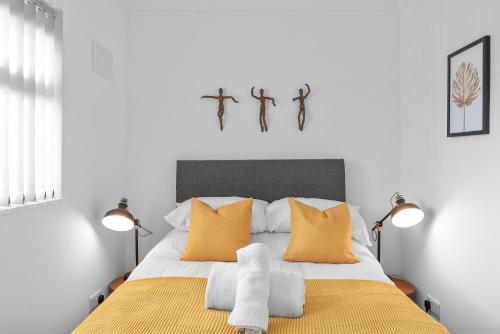 a bedroom with a bed with yellow and white pillows at Contractor Accommodation 4 Bedroom House Sleeps 7 Free Van Parking Near Avonmouth Docks in Avonmouth
