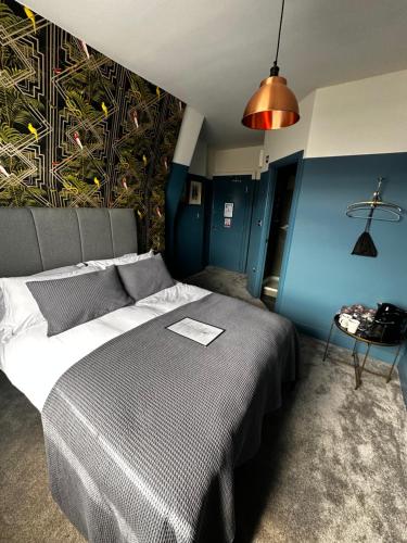 1 dormitorio con 1 cama y una pared con un mural en The Crown Rooms, en Londres