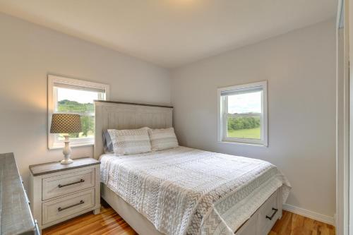 a white bedroom with a bed and two windows at Countryside Hideaway in Greeneville with Fire Pit! in Greeneville