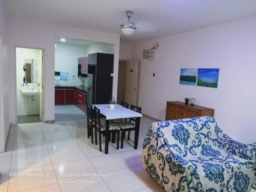 een woonkamer met een bank en een tafel en een keuken bij Rafa Vista Homestay in Shah Alam