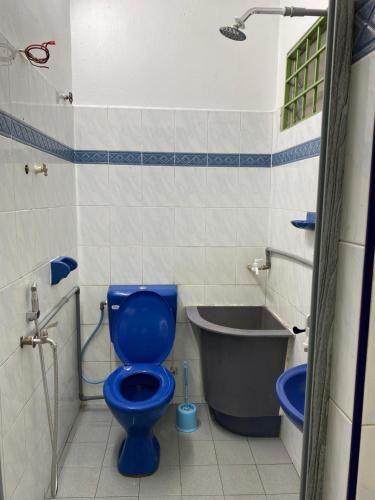 a bathroom with a blue toilet and a bath tub at 83 Homestay in Melaka