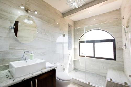 a bathroom with a sink and a toilet and a mirror at Central located in Flamingo, Condo with gorgeous views - Flamingo Marina Resort in Playa Flamingo