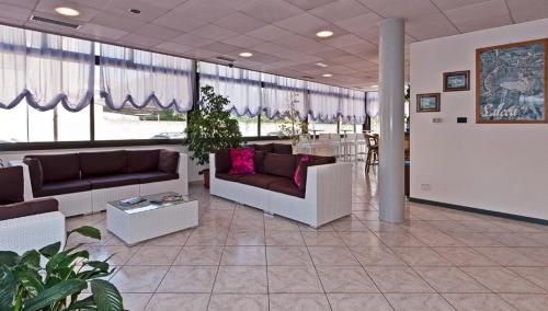 a lobby with couches and a table in a building at Hotel Prestige in Lido di Camaiore