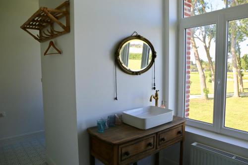 a bathroom with a sink and a mirror on the wall at La Grange du Veld in Téteghem