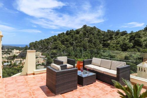 a patio with wicker furniture and a view of a mountain at Villa Monte Leon 7 in Atamaría
