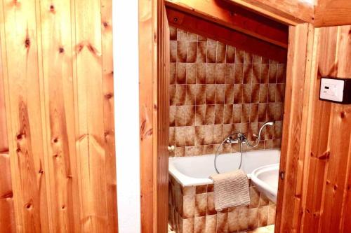 y baño con bañera y lavamanos. en * Chalet inside the nature* [12 guests + WI-FI], en Siror