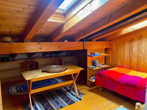 a bedroom with a bed and a desk in a room at * Chalet inside the nature* [12 guests + WI-FI] in Siror