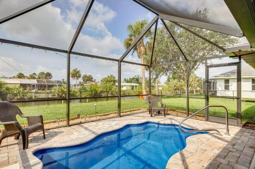a swimming pool in a house with a glass extension at Canalfront Retreat with Heated Pool and Hot Tub! in Port Charlotte