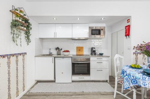 una piccola cucina con armadi bianchi e tavolo di Casa do Barqueiro - Porto a Porto