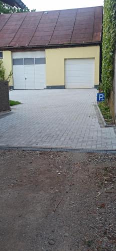 a garage with two garage doors and a brick driveway at Günther´s Ferienwohnung in Pegnitz