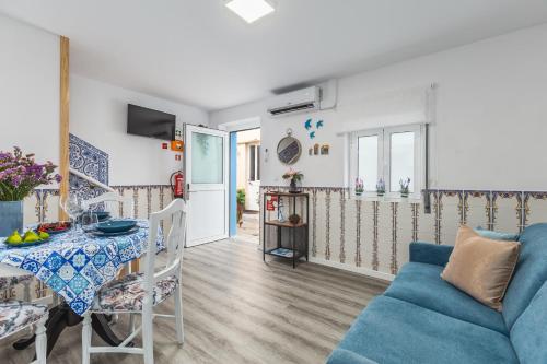 un soggiorno con un divano blu e un tavolo di Casa do Barqueiro - Porto a Porto