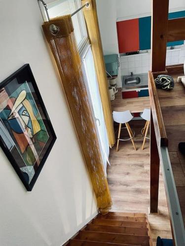 un escalier menant à une cuisine ornée d'une peinture murale. dans l'établissement Studio à 800m de la Cathédrale, à Reims