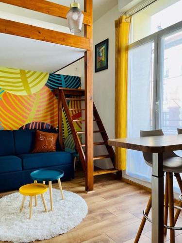 un salon avec un canapé bleu et une table dans l'établissement Studio à 800m de la Cathédrale, à Reims