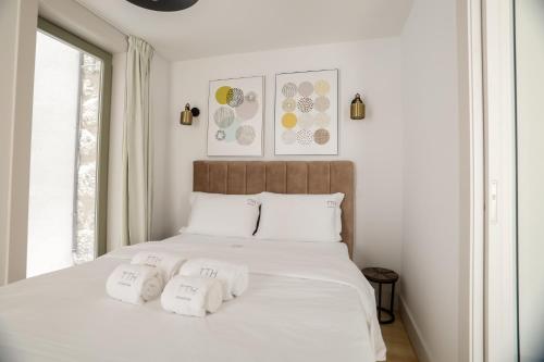 a white bed with three folded towels on it at Trindade Apartments by PHC in Porto