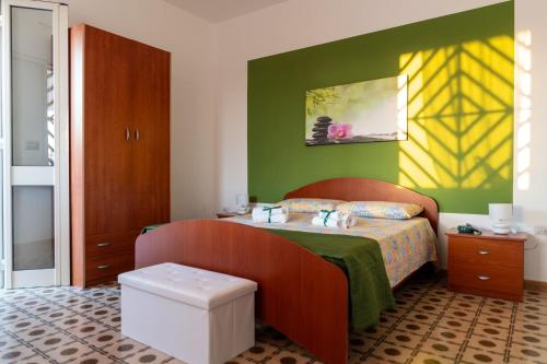 a bedroom with a bed with a yellow and green wall at Casa Vacanze da Nino in Torre Lapillo