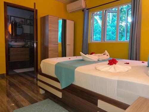 a bedroom with a bed with a flower on it at Chloe's Cottage Self-Catering in La Digue