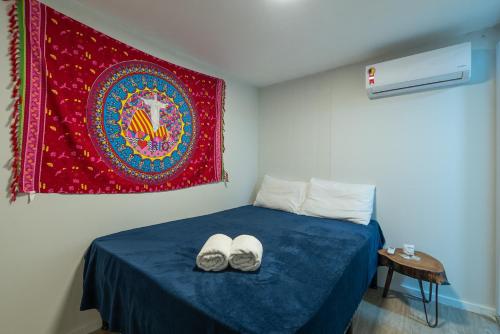 1 dormitorio con 1 cama con tapiz rojo en Secreto Quartos, en Río de Janeiro