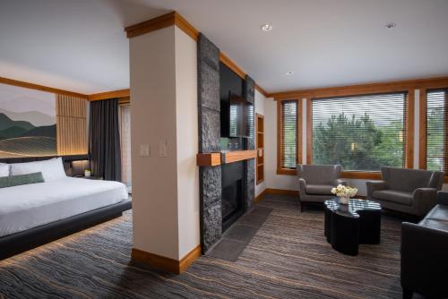 um quarto de hotel com uma cama e uma lareira em Nita Lake Lodge em Whistler