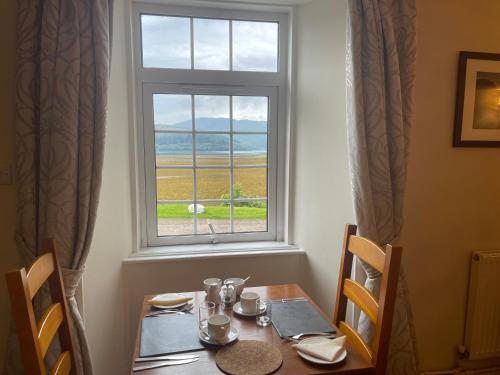 a table and a window with a table and chairs at The Strontian Hotel in Strontian