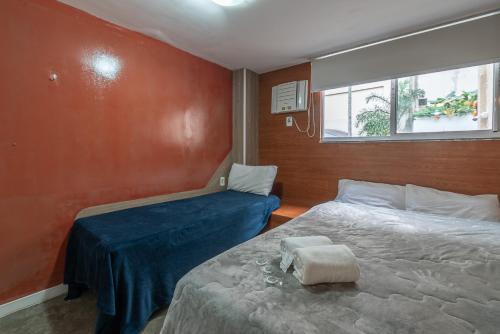 a small bedroom with two beds and a window at Secreto Quartos in Rio de Janeiro