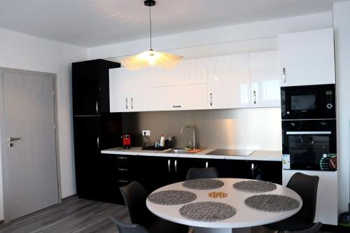 a kitchen with a table and a kitchen with white cabinets at Apart Relax Baile Felix in Cordău