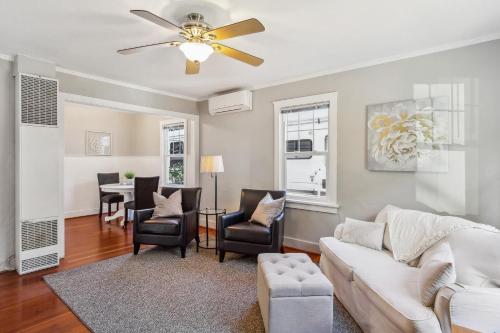 a living room with a white couch and chairs at Charming Eugene Retreat Private Hot Tub and Yard! in Eugene