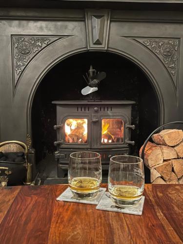 two glasses of whiskey on a table in front of a fireplace at The Strontian Hotel in Strontian