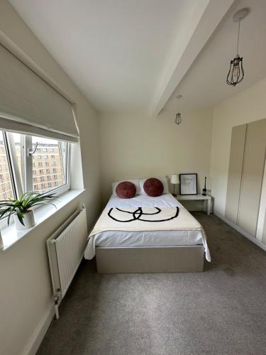 a bedroom with a bed and two windows at Central studioflat Chelsea in London