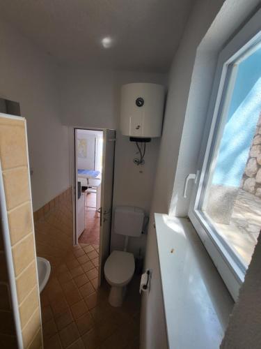 baño con aseo y lavabo y ventana en Apartment Blaženka, en Klada