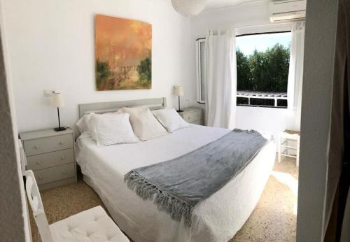 Un dormitorio blanco con una cama grande y una ventana. en Ferienhaus SolDénia, en Denia