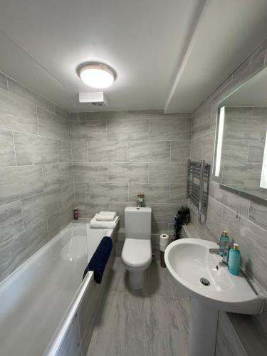 a bathroom with a toilet and a sink and a tub at Central studioflat Chelsea in London