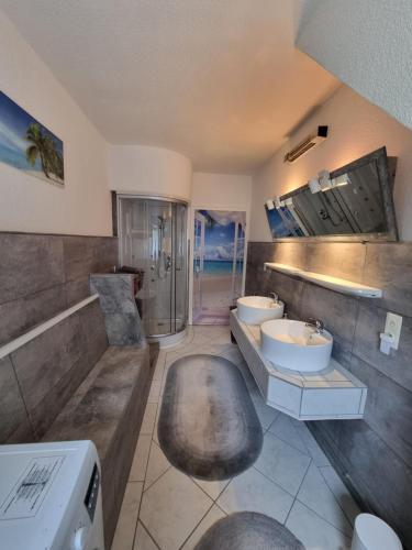 a large bathroom with two sinks and a shower at Pension Zum Burgwächter in Rahden