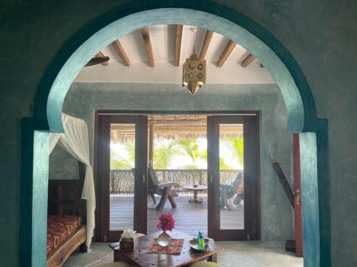 a living room with an arched doorway and a table at Casa Paradis in Jambiani