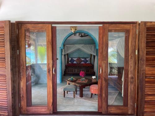 an open door to a room with a bed and a table at Casa Paradis in Jambiani