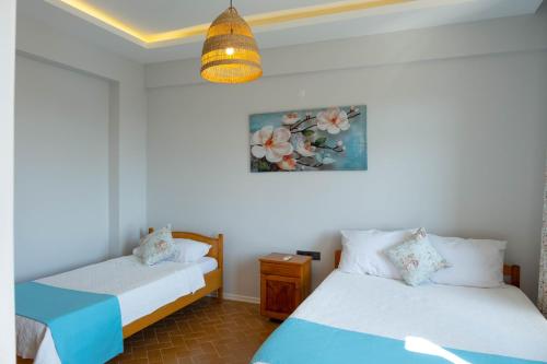 a bedroom with two beds and a picture on the wall at Kibele Hotel in Oludeniz