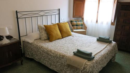 a bedroom with a large bed with yellow pillows at Casa Moreno in El Cuervo