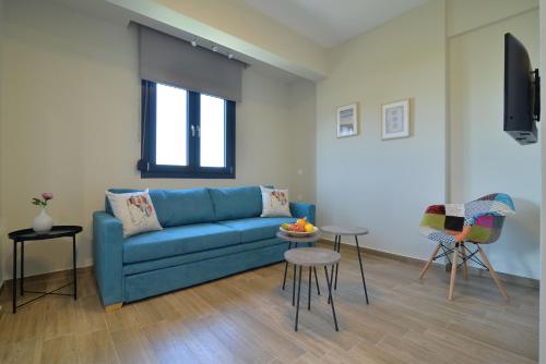 sala de estar con sofá azul y mesa en Niel Holiday Apartments, Panel Hospitality Homes & Villas en Leptokarya