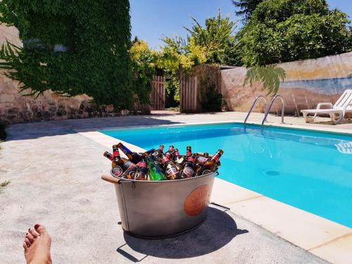 un cubo de botellas de cerveza sentado junto a una piscina en Casa La Alameda, en Marazuela