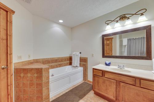 uma casa de banho com uma banheira, um lavatório e um espelho. em Slaty Fork Home about 6 Mi to Snowshoe Mountain Resort em Slaty Fork