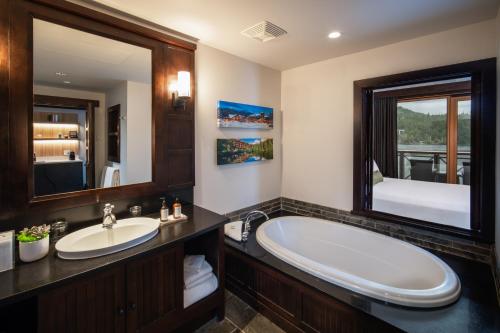 a bathroom with a tub and a large mirror at Nita Lake Lodge in Whistler